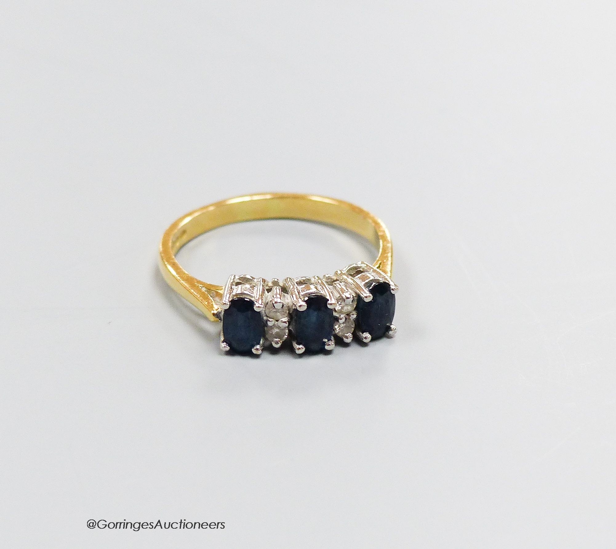 An 18ct gold sapphire and diamond dress ring, size N, gross 3.4g.